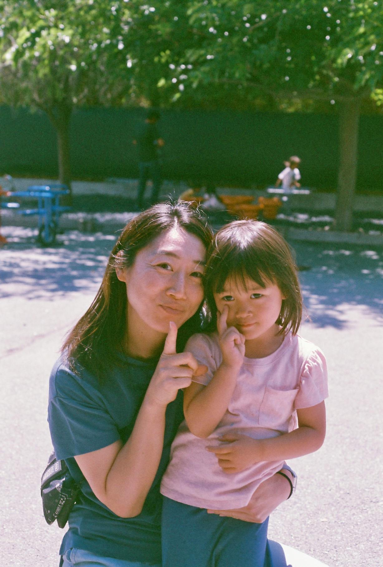 Person and child posing with fingers on their faces