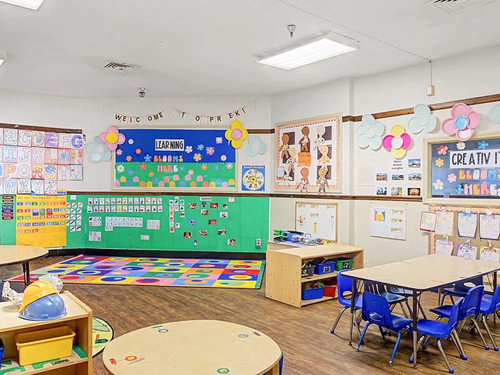 Colorful preschool classroom with various learning charts and small tables and chairs