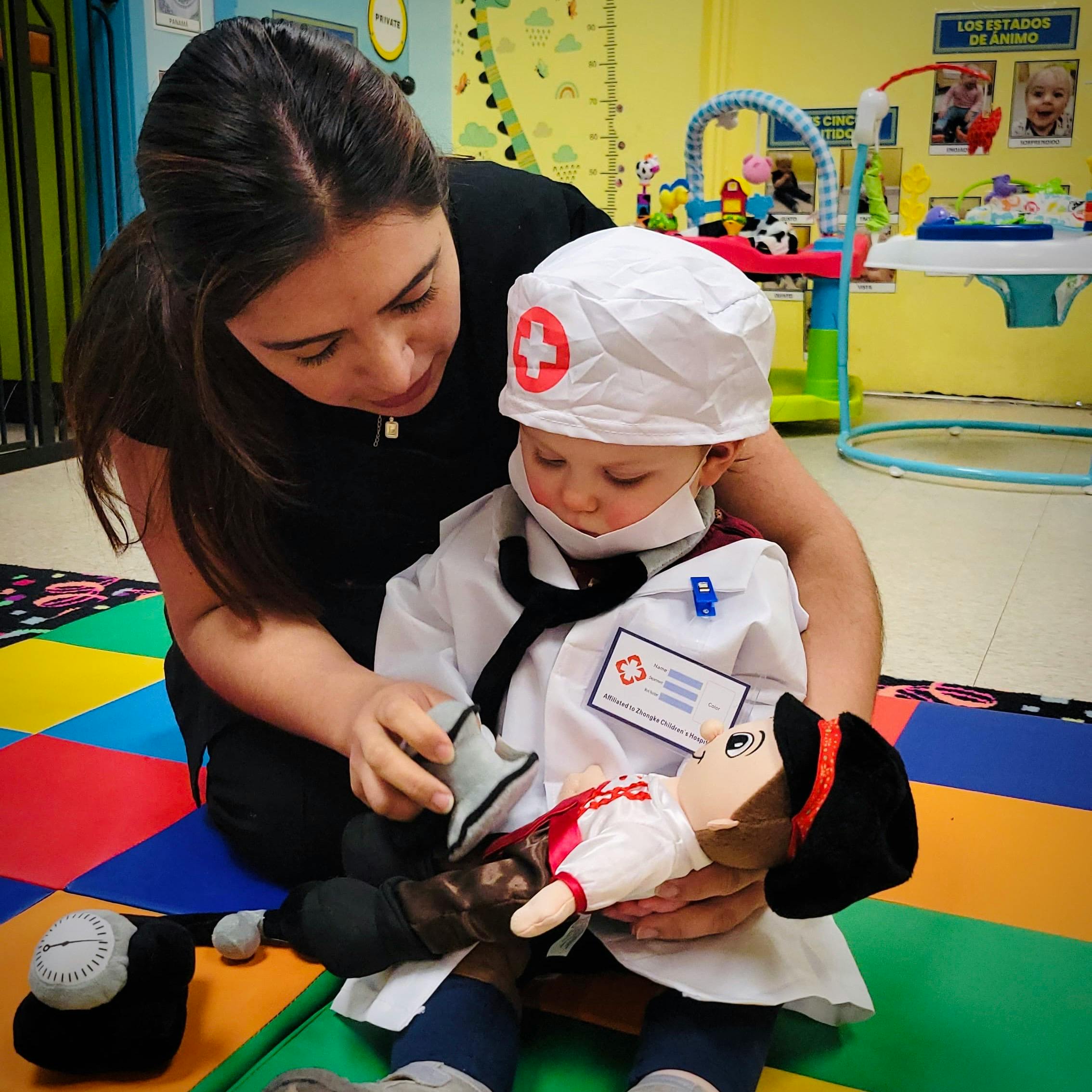Person helping a child in a doctor costume hold a doll