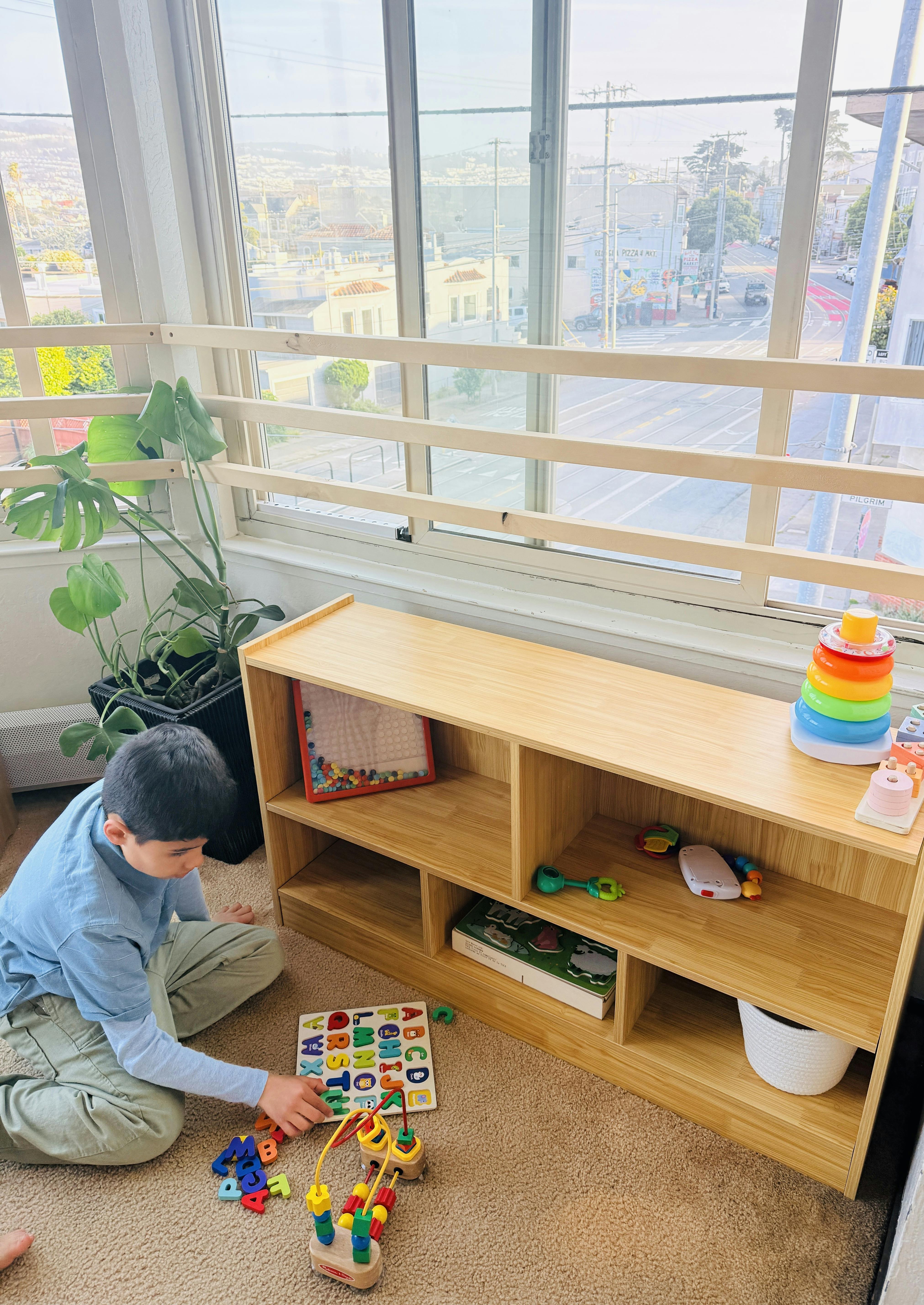 Child sitting on the floor and playing with a letter puzzle