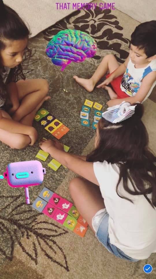 Three children playing a board game on the floor