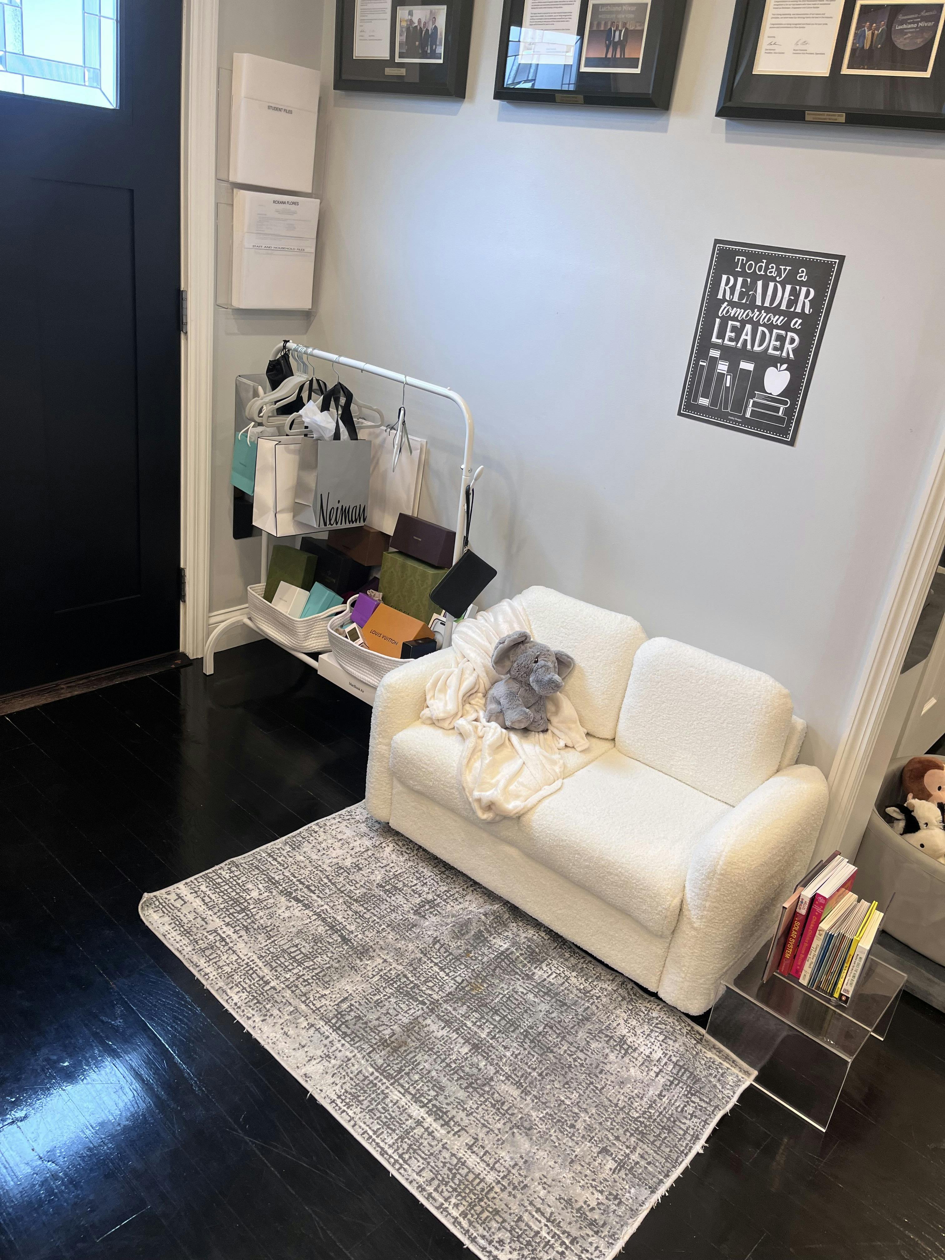 Small white sofa with a plush elephant toy and blanket in a room