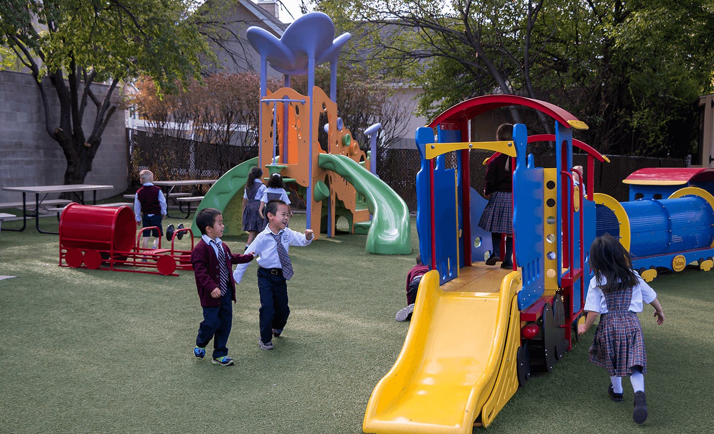Children playing on a playground with slides and play structures