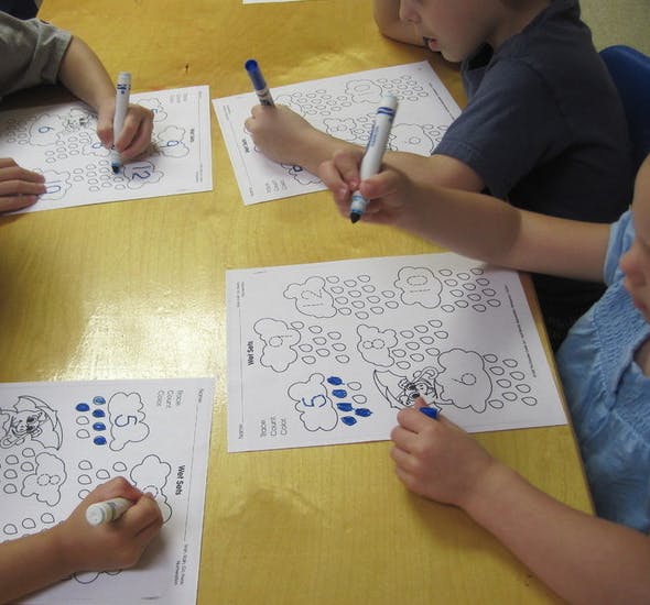 Children coloring worksheets at a table