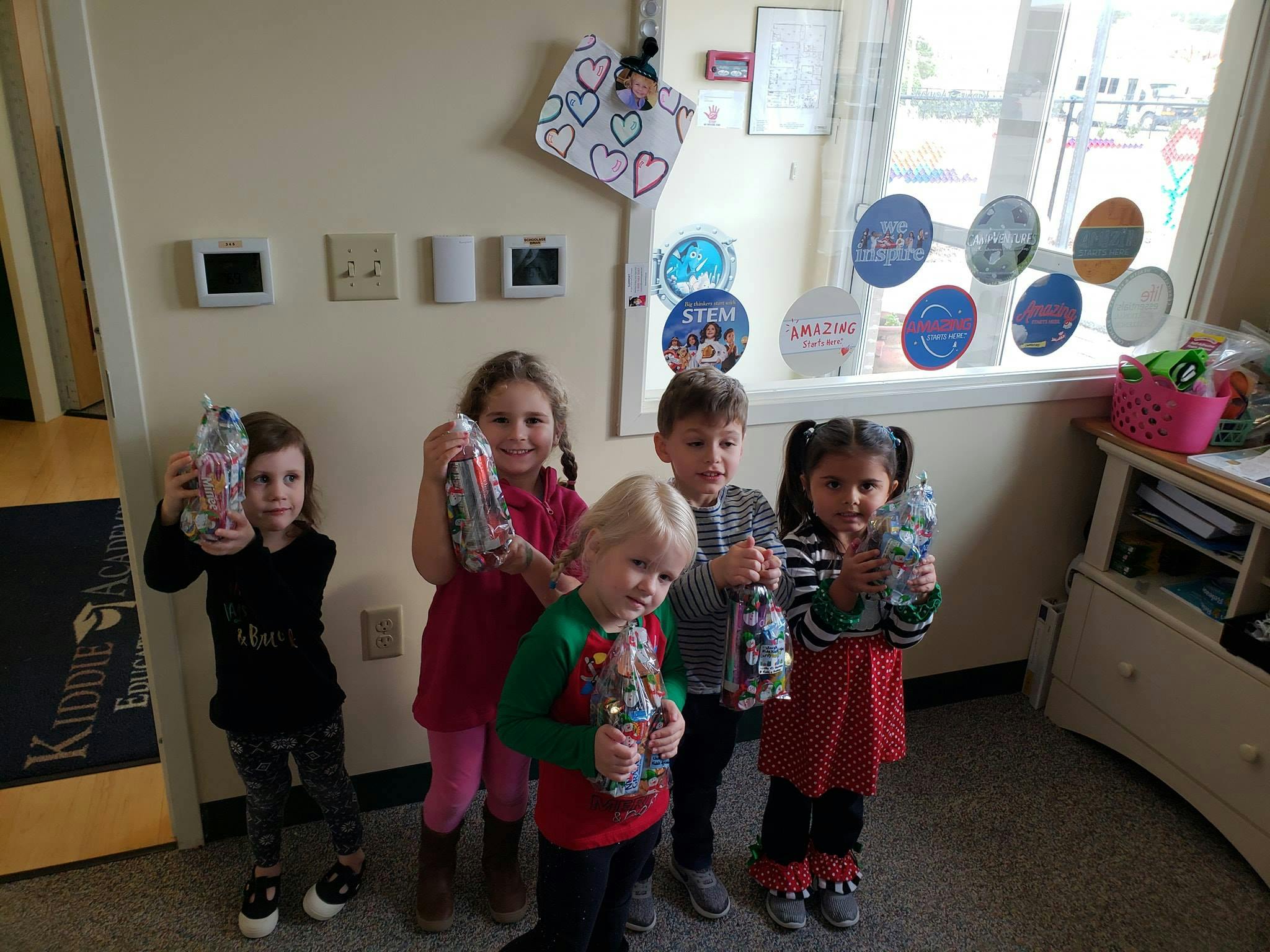 Five children holding decorated plastic bottles