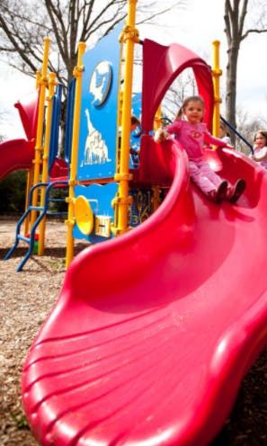 Child on a red slide at a playground