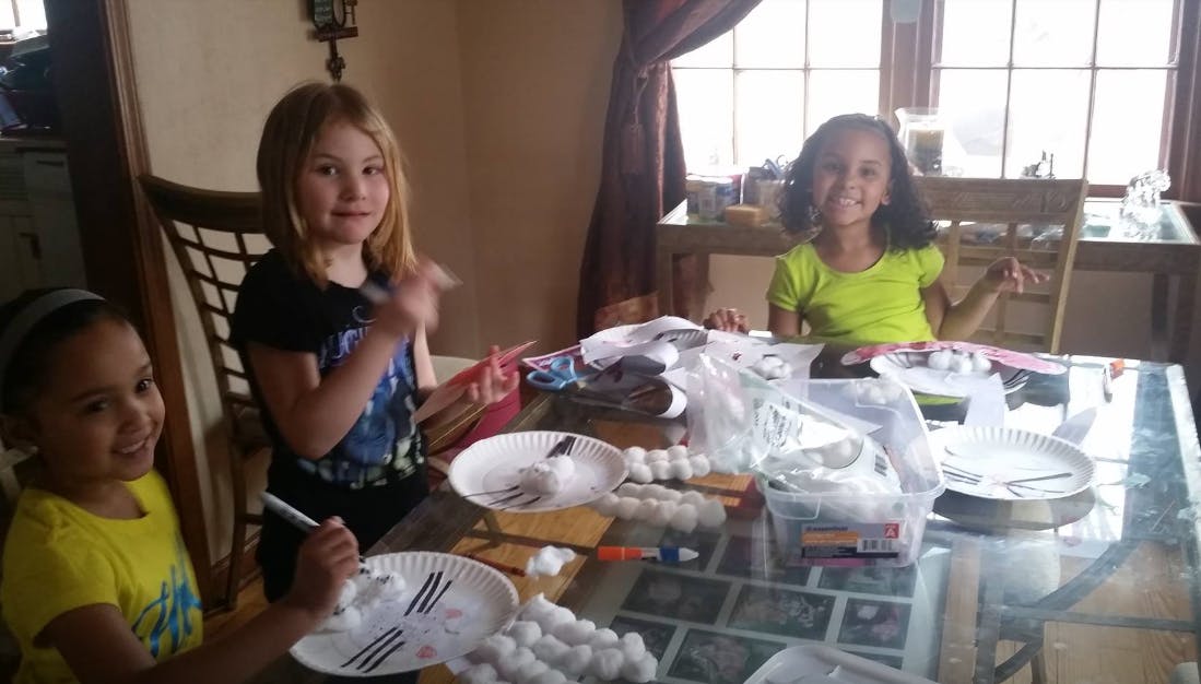 Three children at a table with craft supplies