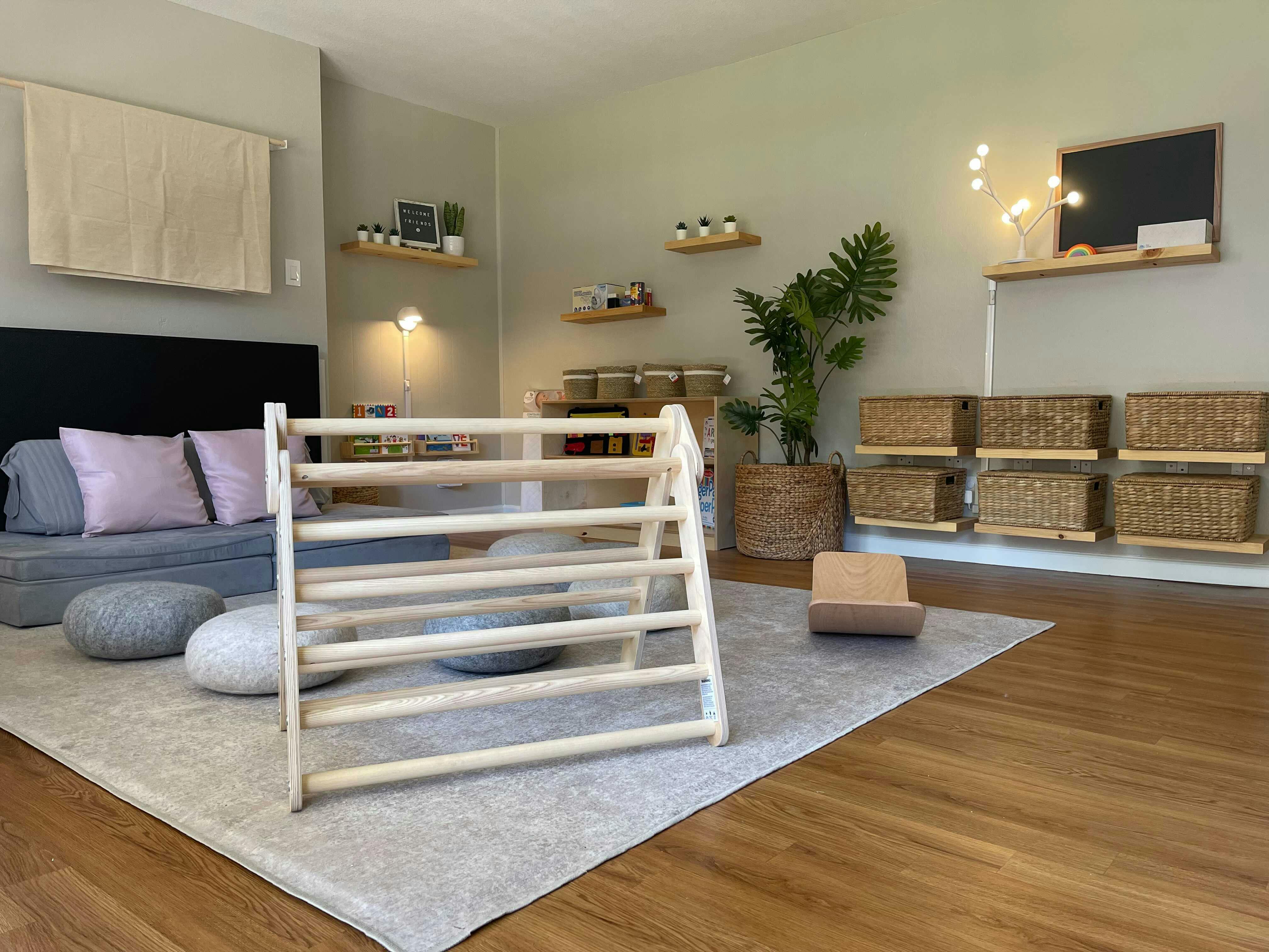 Wooden climbing triangle in a room with a sofa and shelves