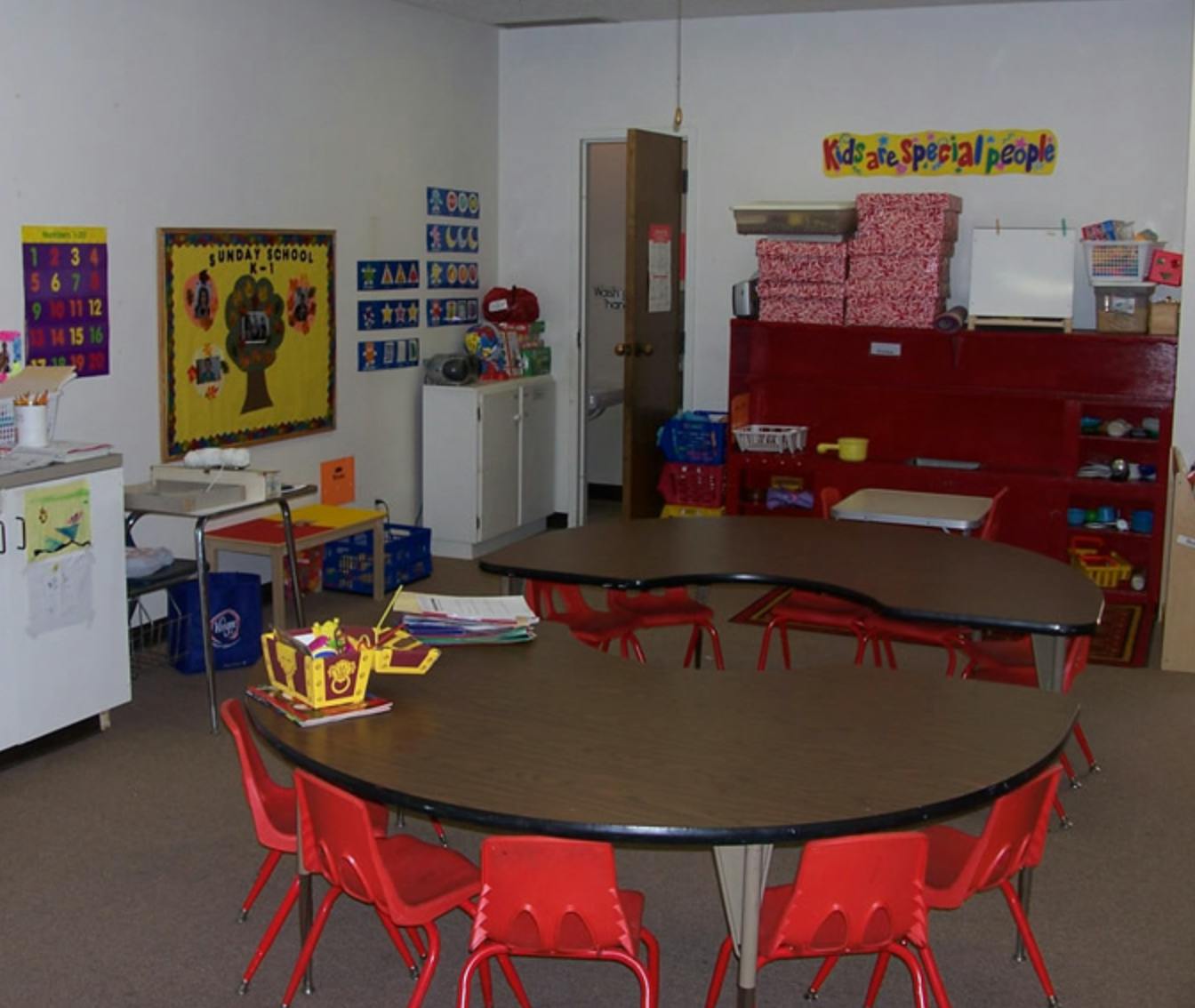 Classroom with small tables and red chairs
