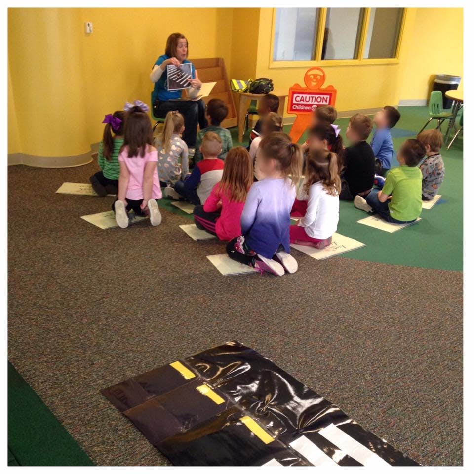 Adult reading to a group of children in a classroom