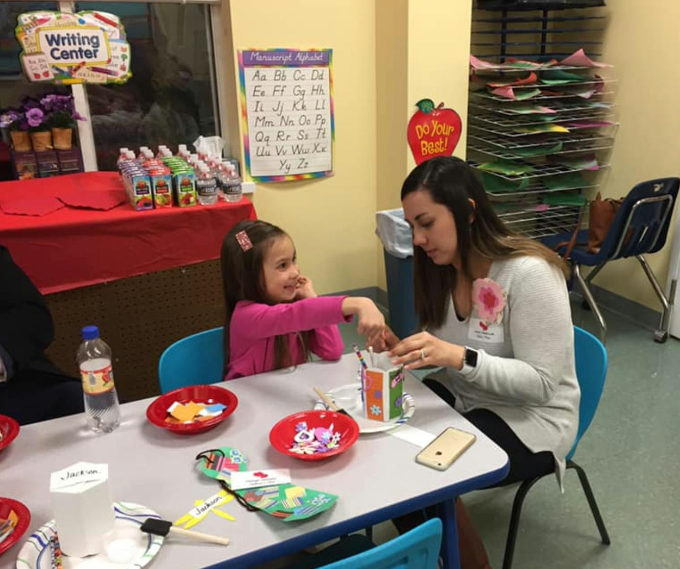Adult and child at a table with craft supplies