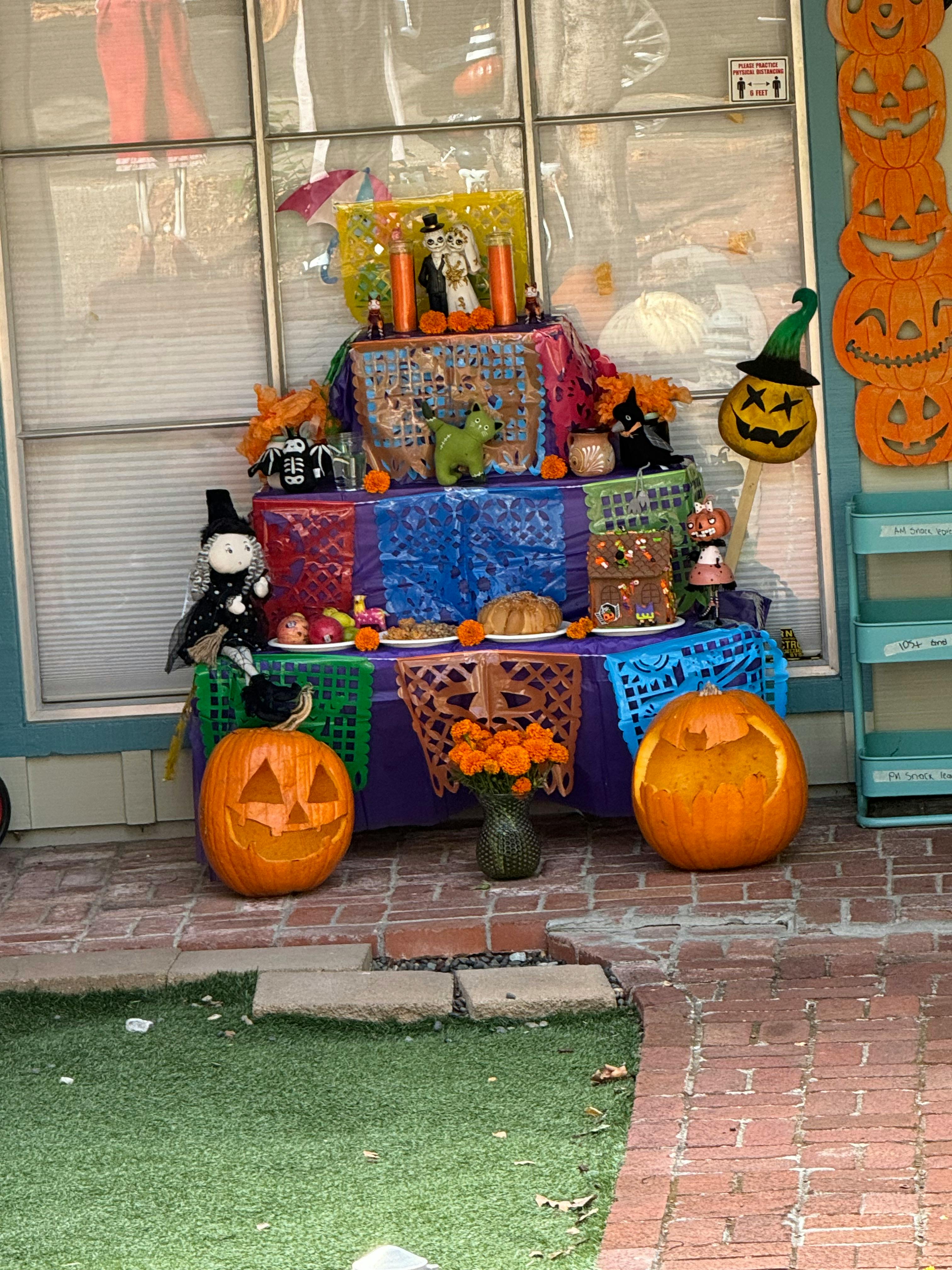 Day of the Dead altar with offerings and carved pumpkins