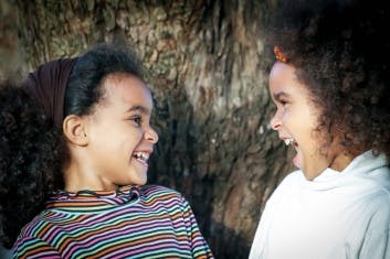 Two children looking at each other and laughing