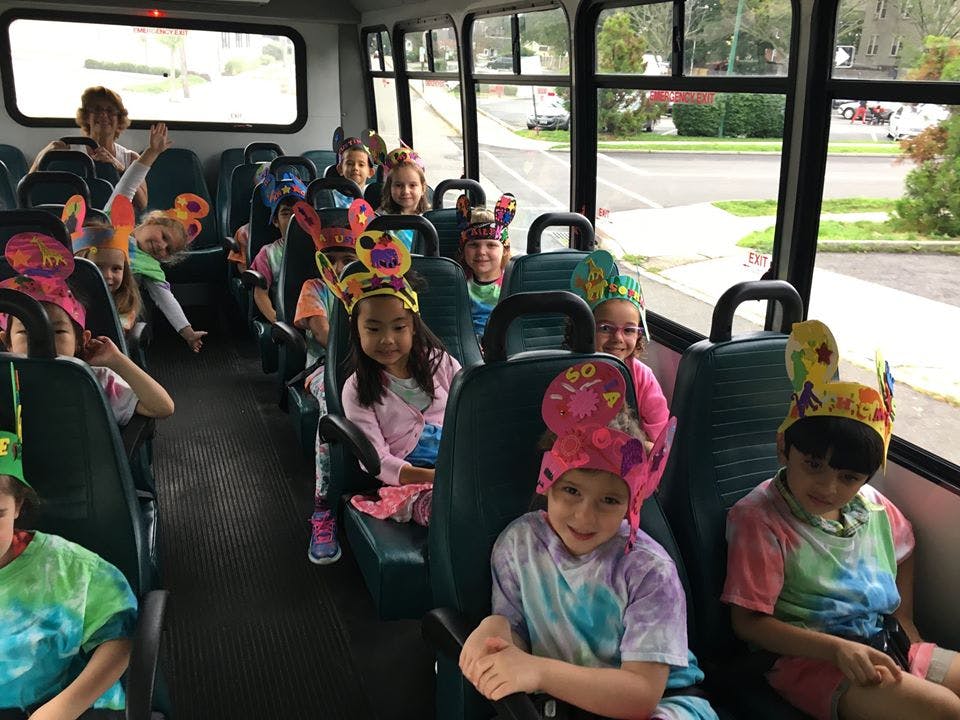 Children wearing colorful hats sitting on a bus
