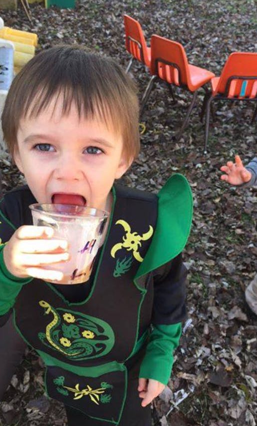 Child in costume drinking from a cup