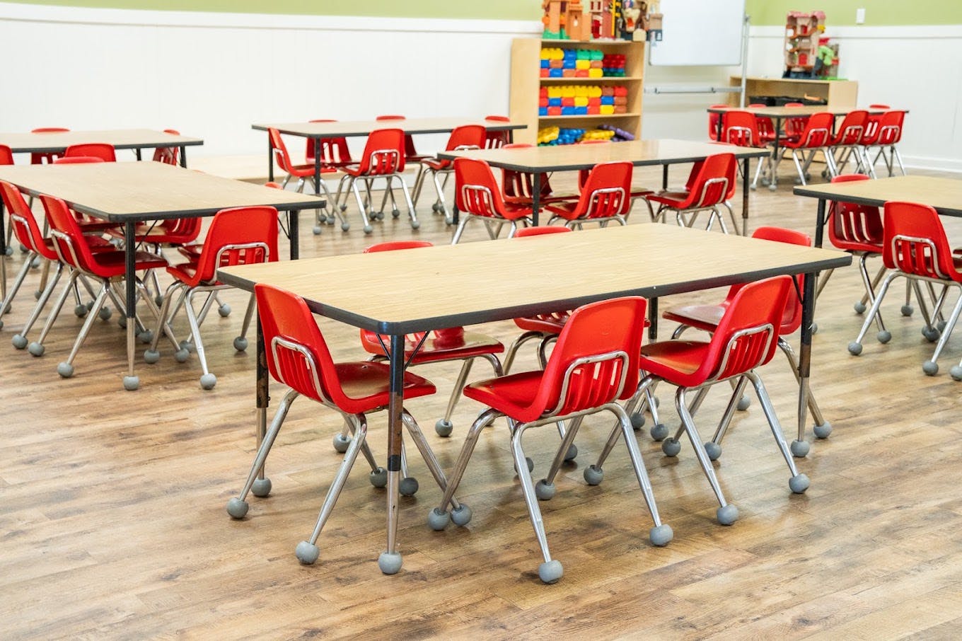 Empty tables and red chairs in a classroom
