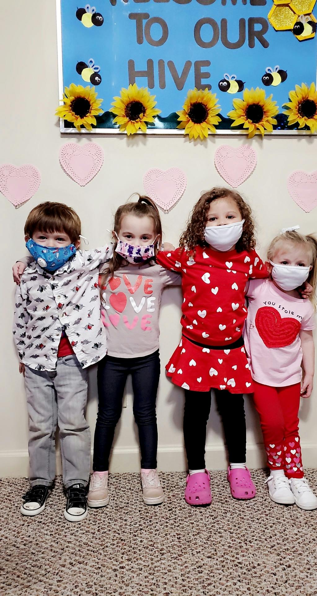 Four children wearing face masks standing together
