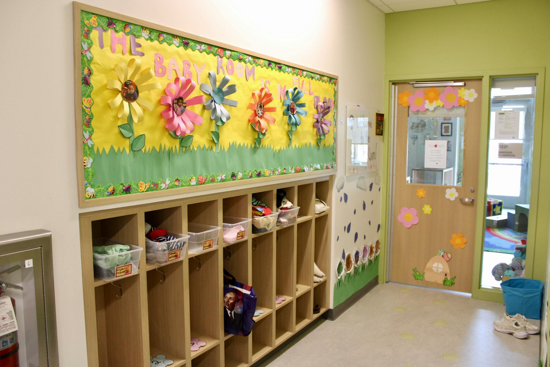 Classroom hallway with cubbies and a bulletin board with flower decorations
