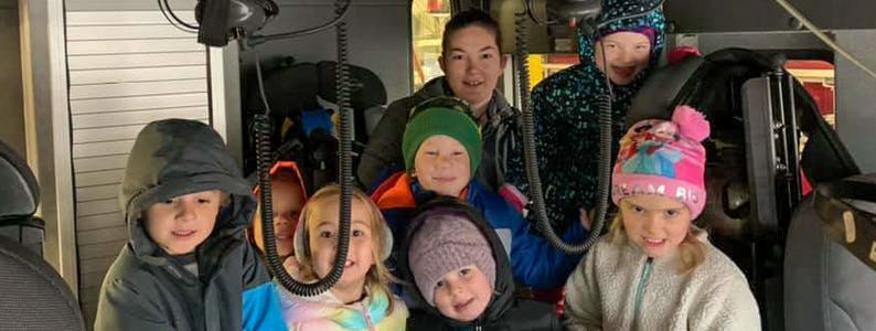 Adult and multiple children in winter hats and hooded clothing