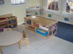 Child's play area with small table and chairs, toy shelves