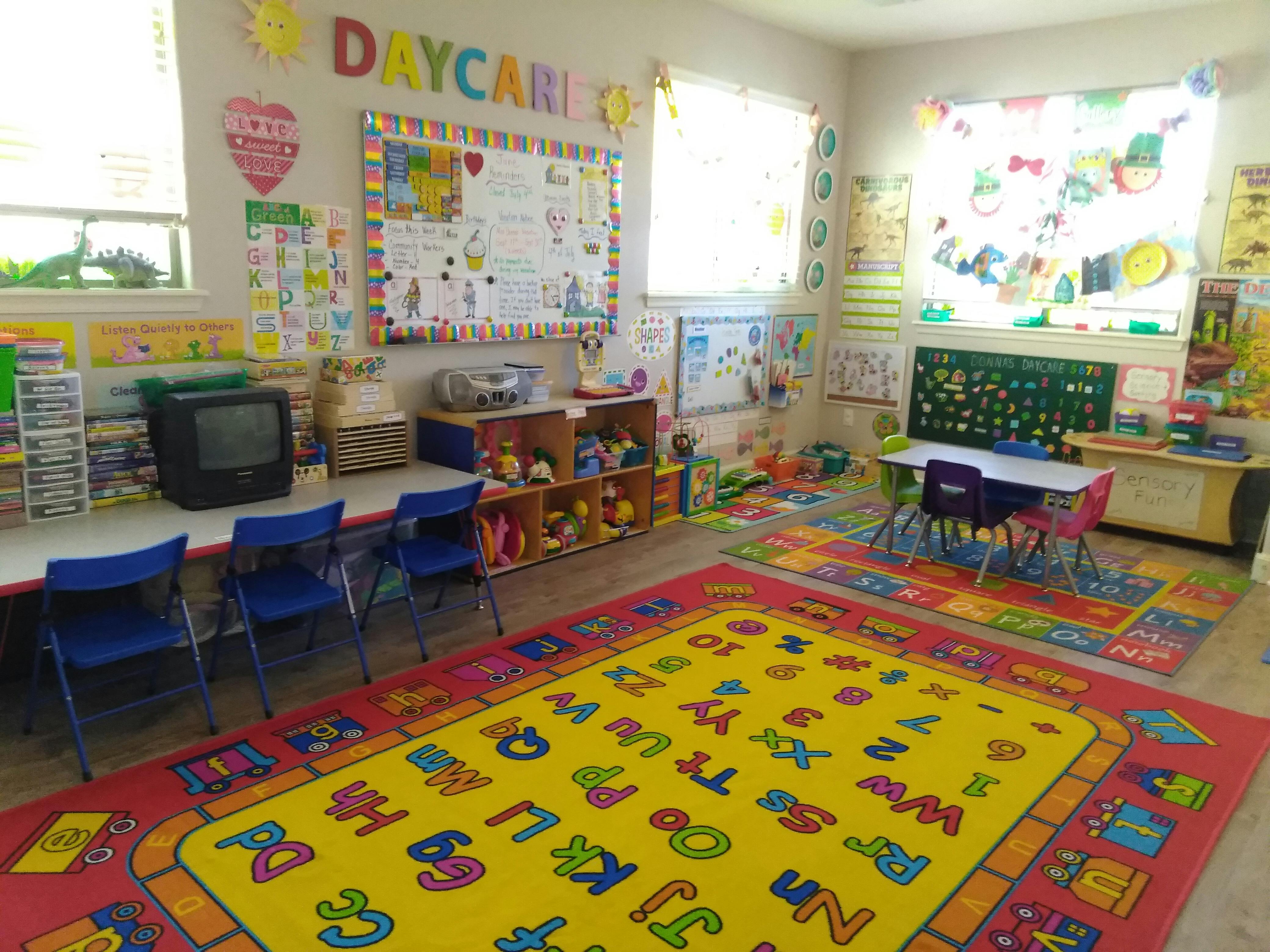 Daycare classroom with colorful rugs, tables, and learning materials