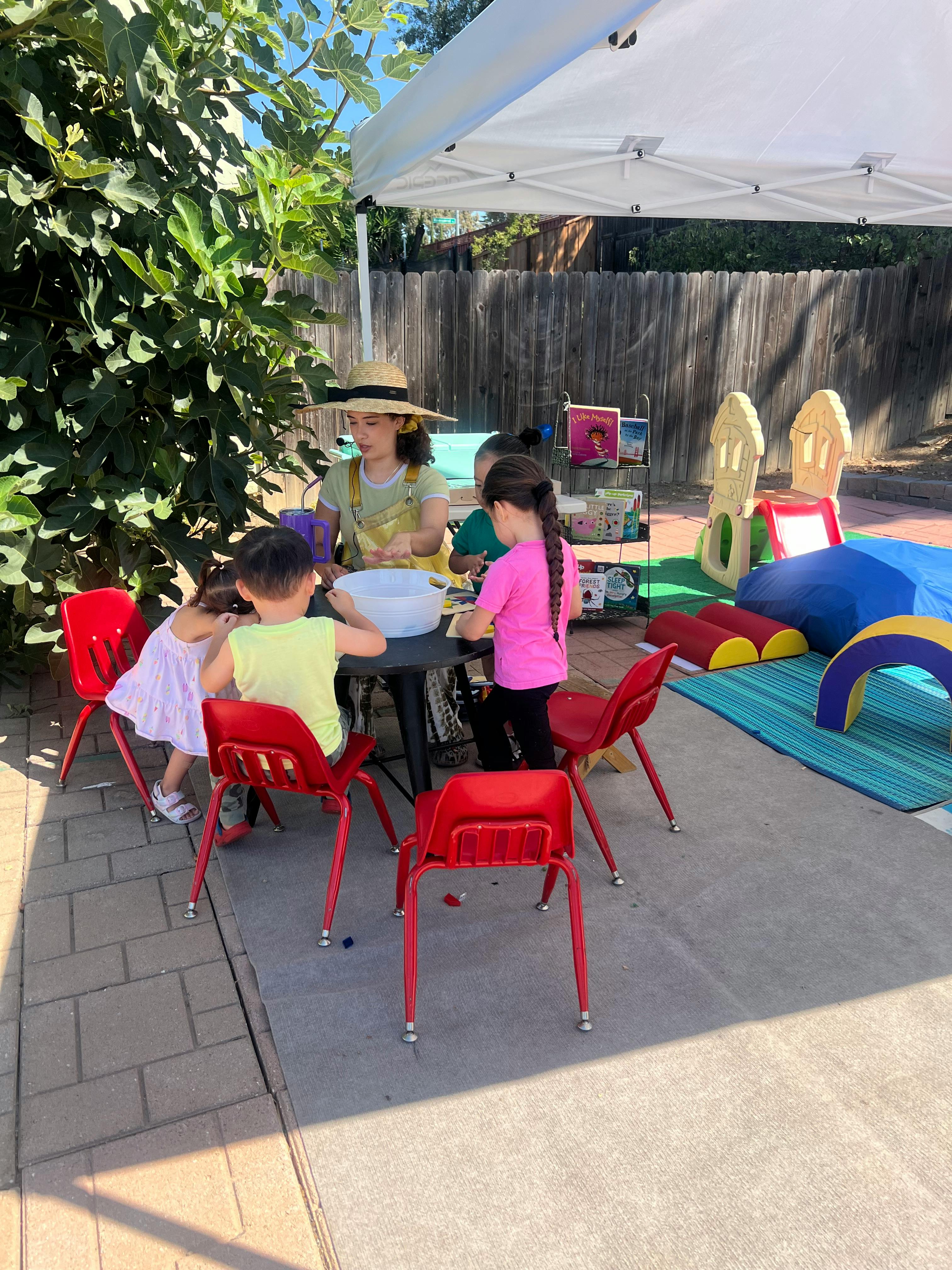 Adult and children gathered around a table outdoors