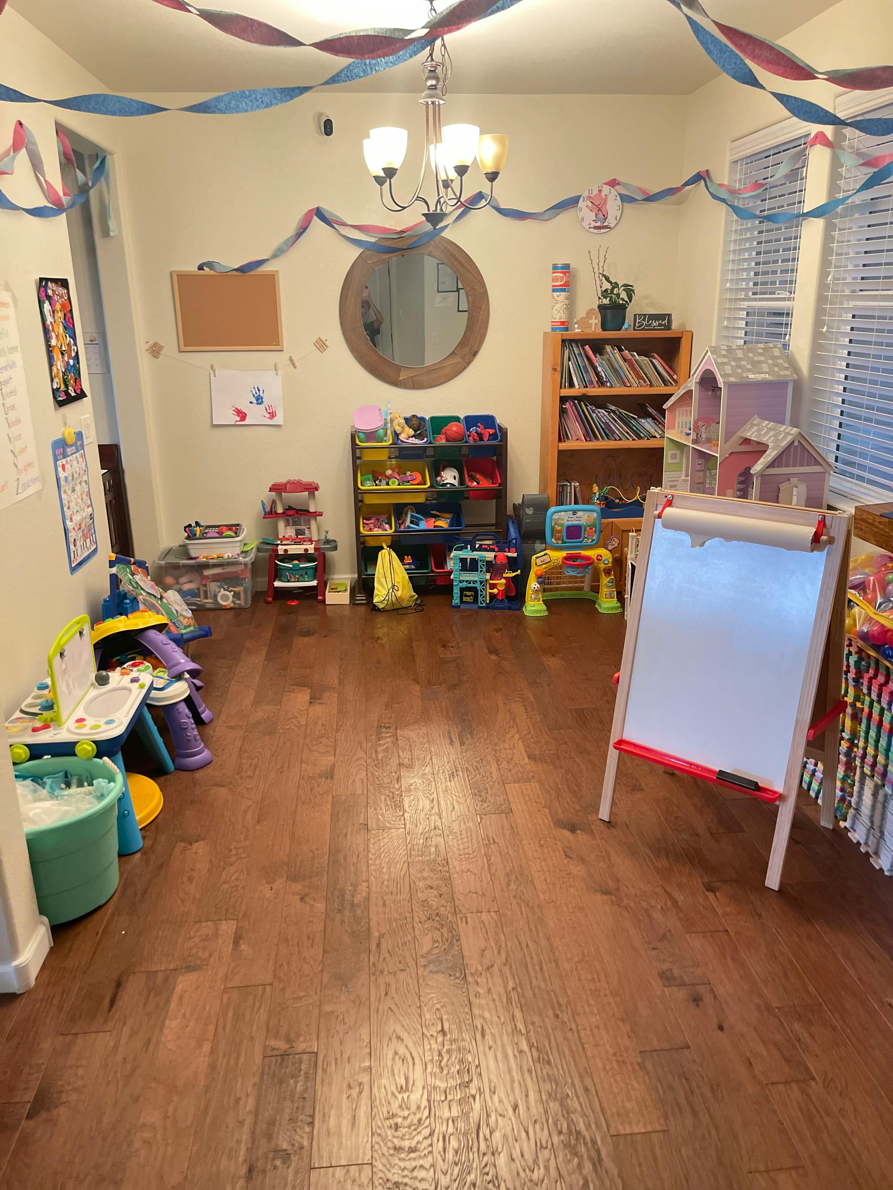 Room decorated with streamers and filled with children's toys and furniture