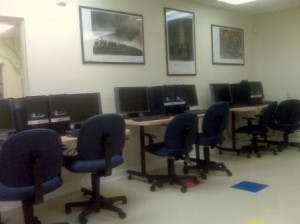 Computer lab with multiple workstations and chairs