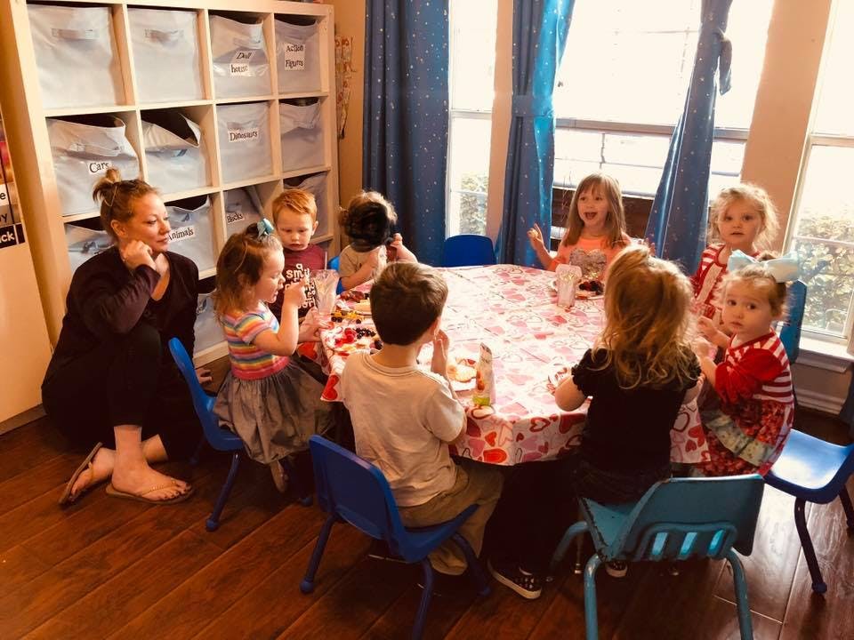 Adult and children sitting around a table in a classroom