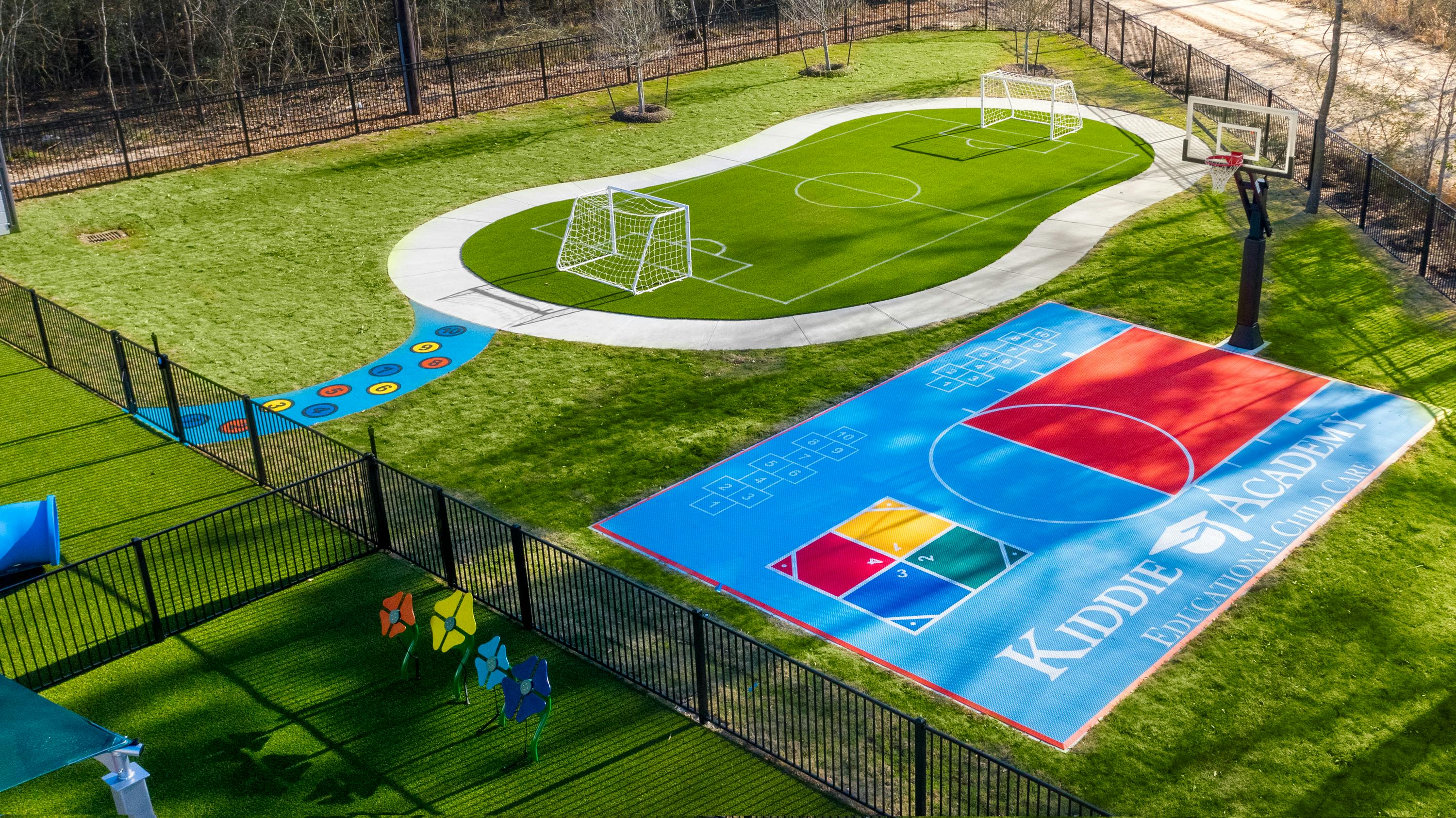 Outdoor play area with a small soccer field and a basketball court