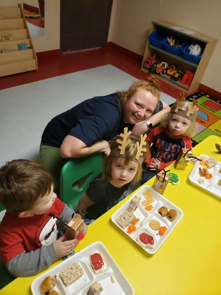 Adult and three children at a table with food trays