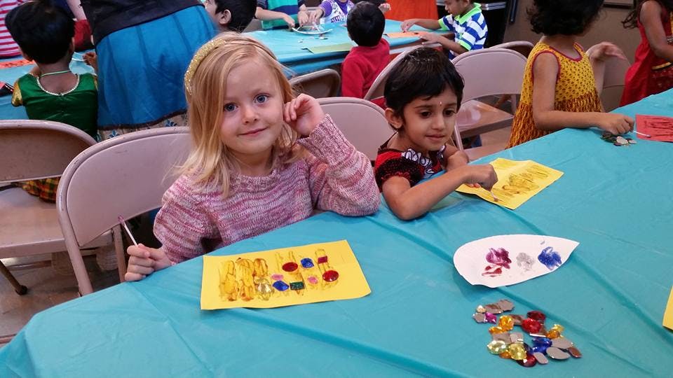 Two children at a table with craft supplies