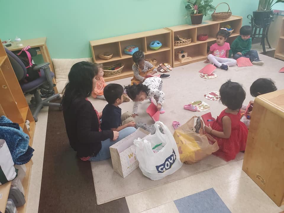 Adult and children sitting on the floor in a classroom