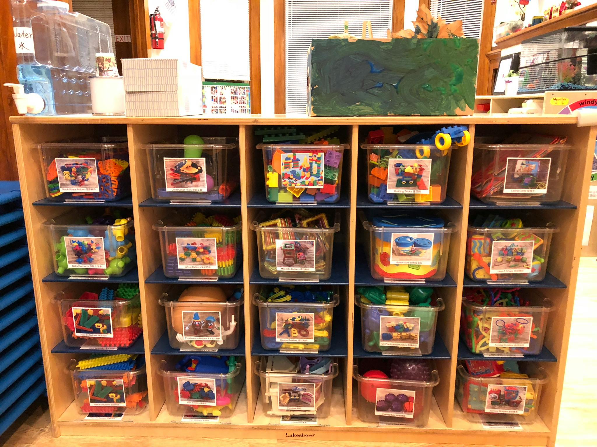 Shelves with clear bins filled with colorful toys and building blocks