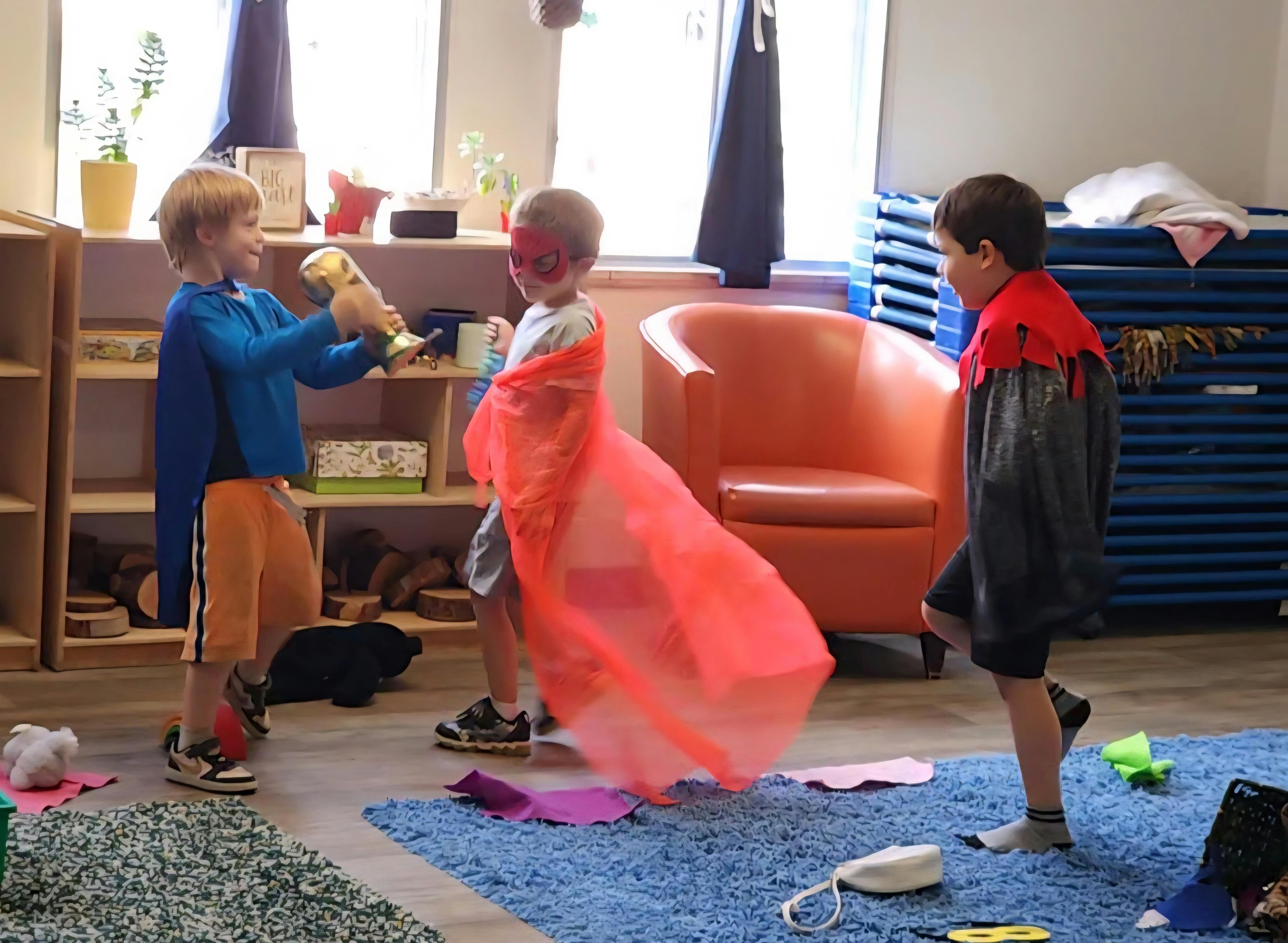 Three children in superhero costumes playing in a room