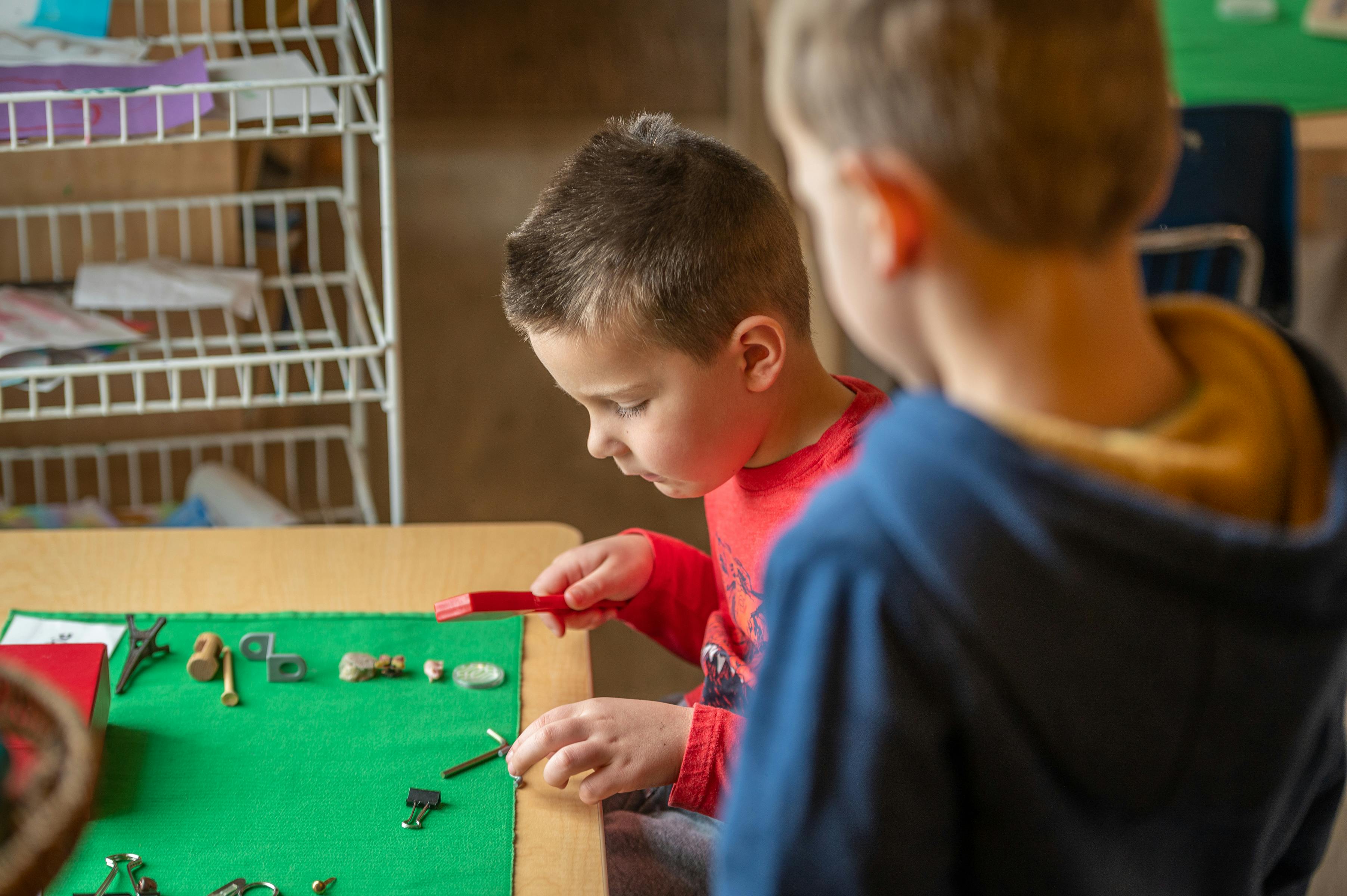Child playing with small objects on a green mat