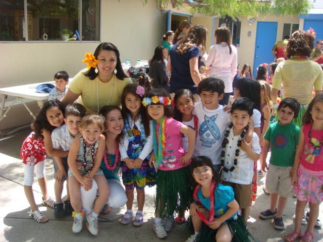 Adults and children posing for a group photo outdoors