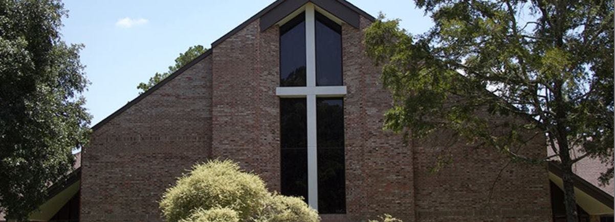 Brick building with a large window shaped like a cross