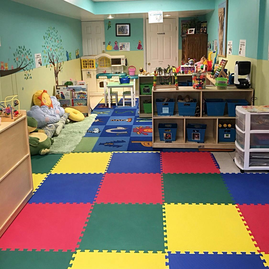 Playroom with colorful floor mats and various toys and furniture