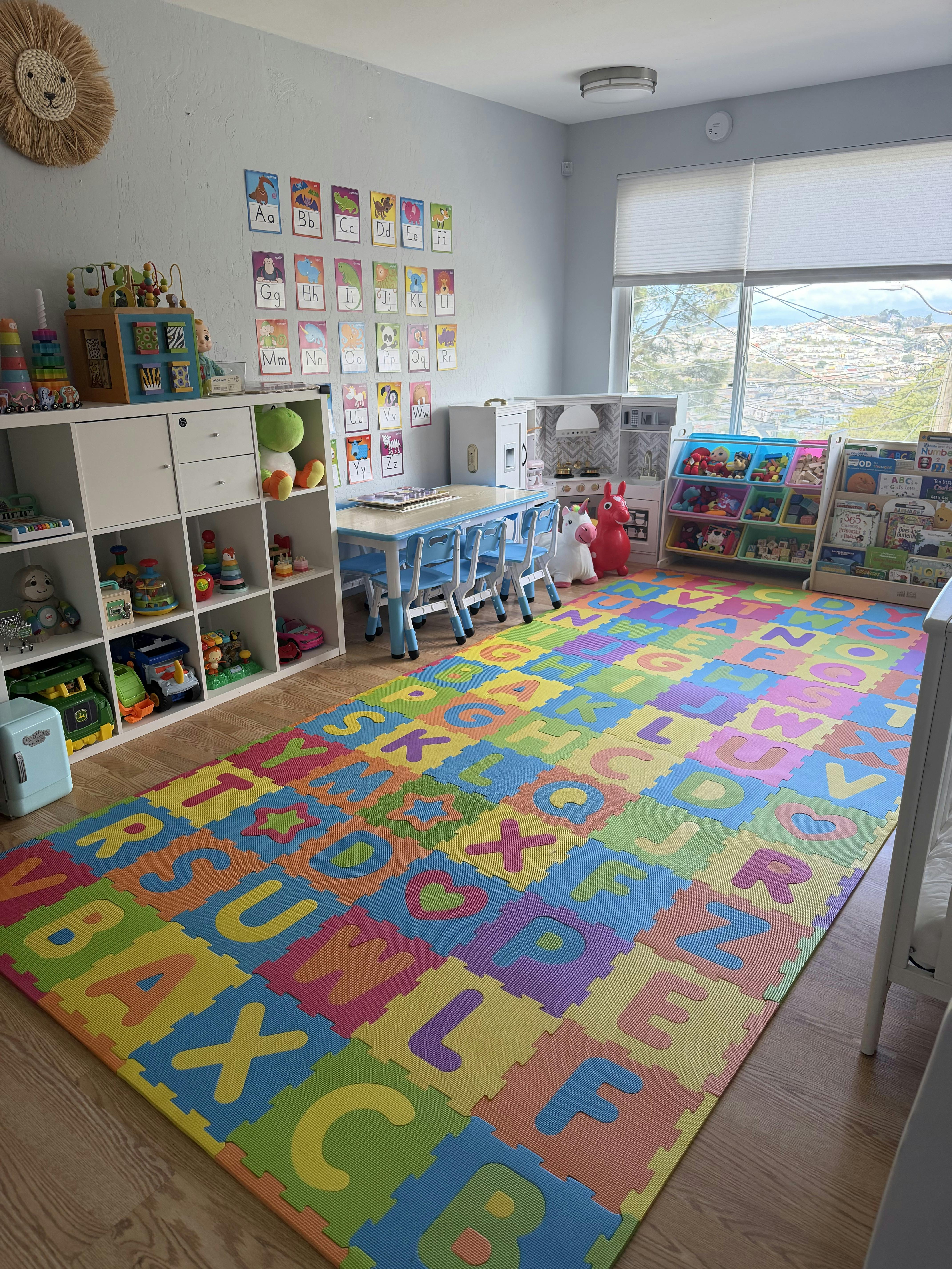 Colorful playroom with alphabet floor mat, wall posters, and storage shelves