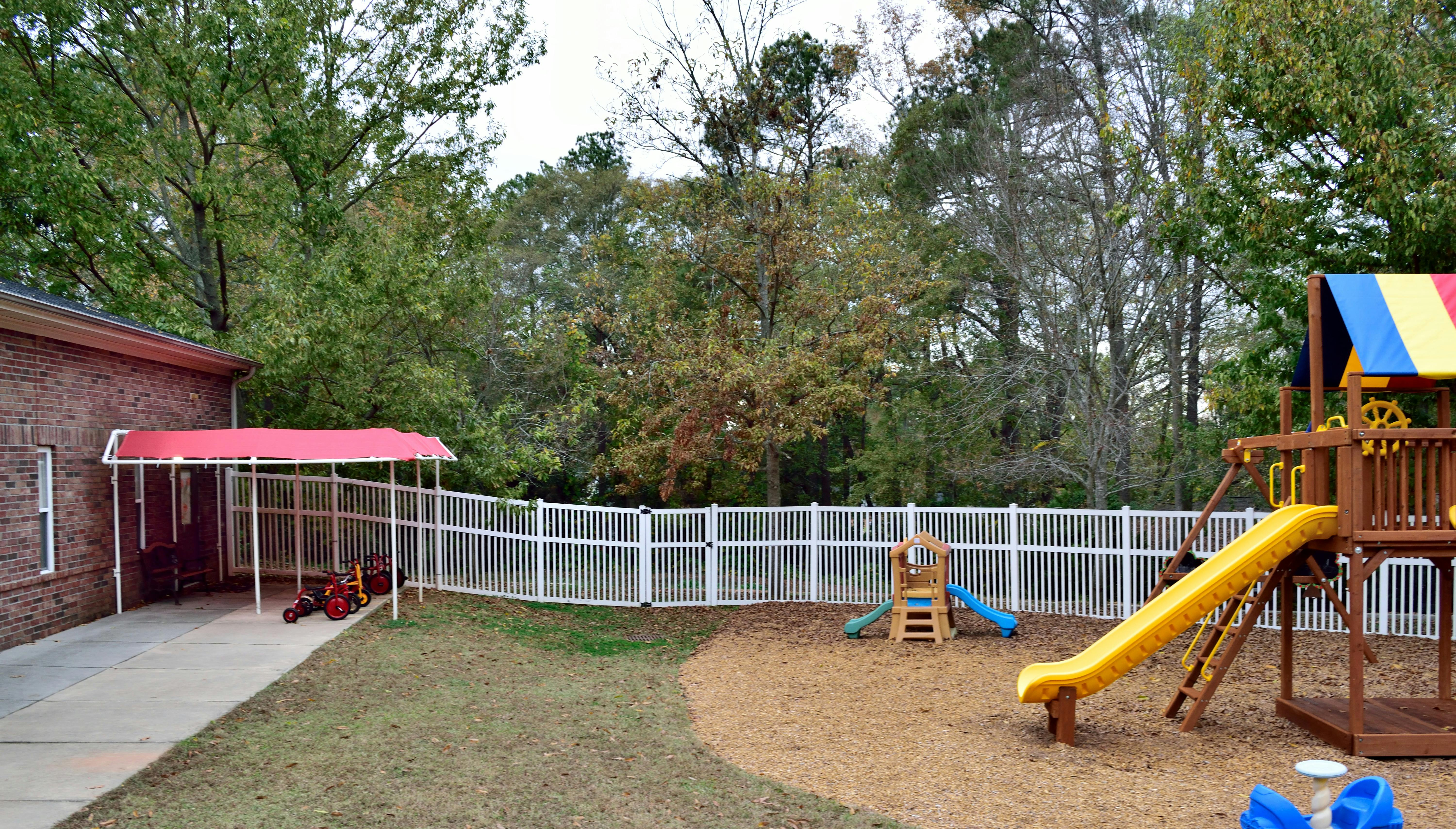 Playground with slides and swings next to a building with a red awning