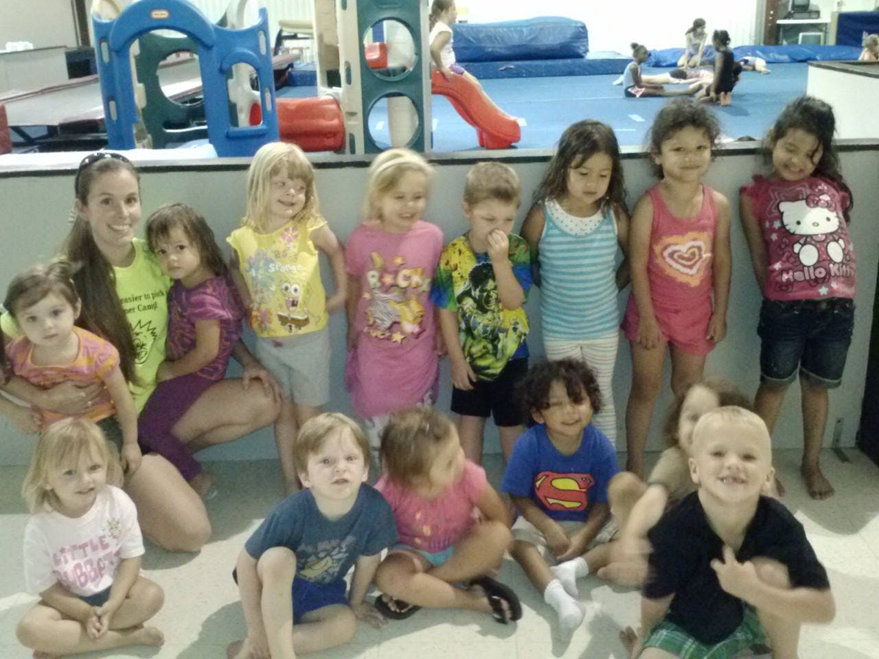 Adult and children posing for a group photo in a play area