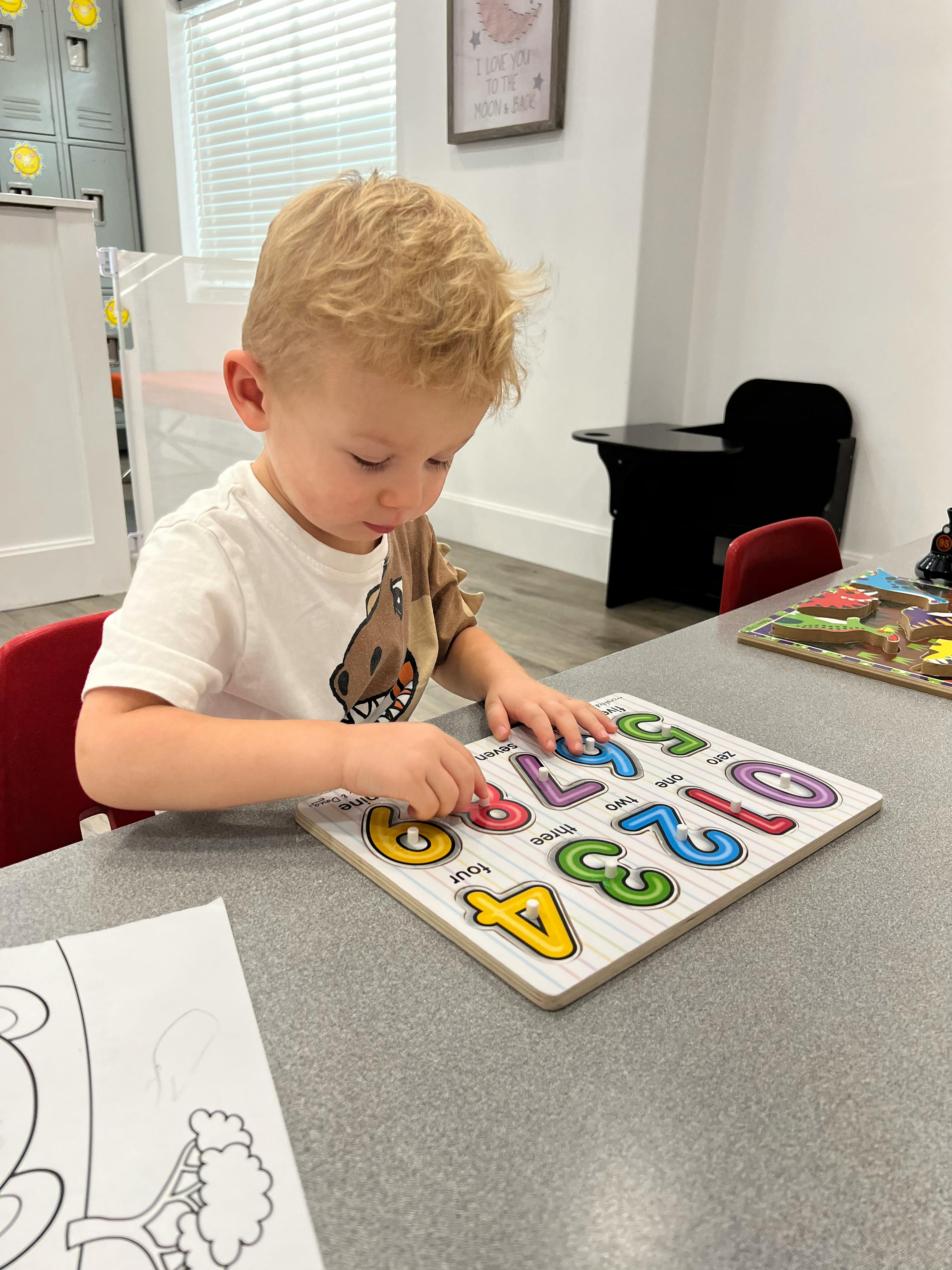 Child playing with a number puzzle on a table
