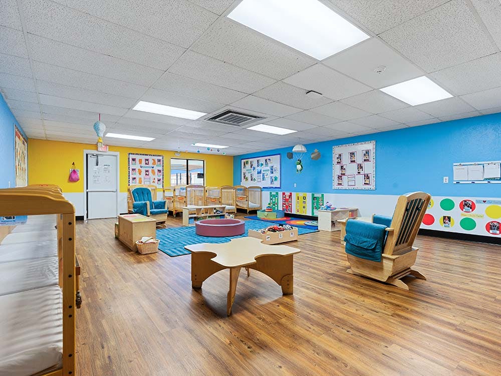 Classroom with cribs, chairs, and colorful walls