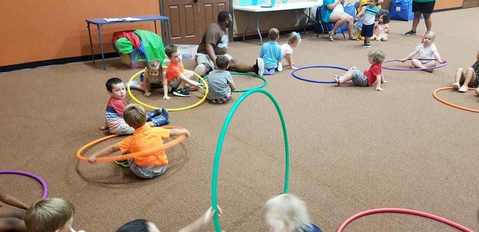 Children playing with hula hoops on the floor