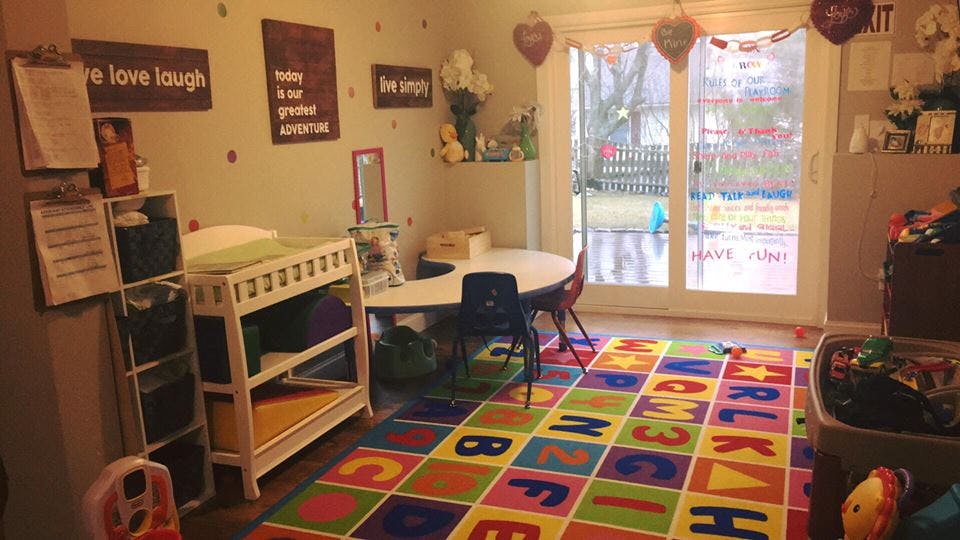 Child's room with changing table, small table and chairs, and alphabet rug