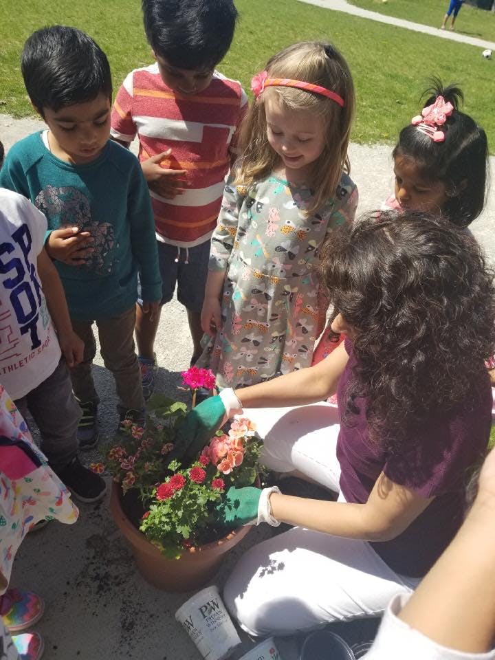 Adult and children planting flowers in a pot