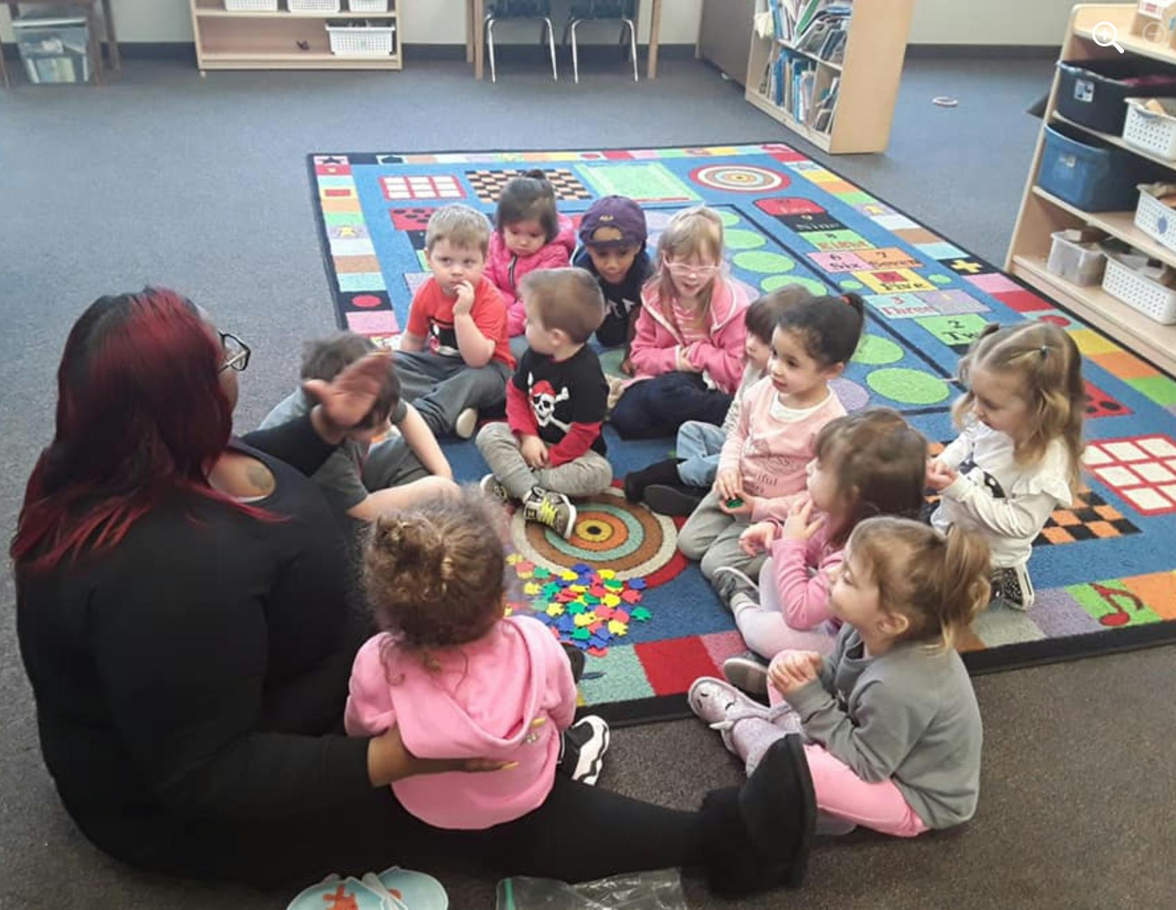 Person sitting on floor with a group of children