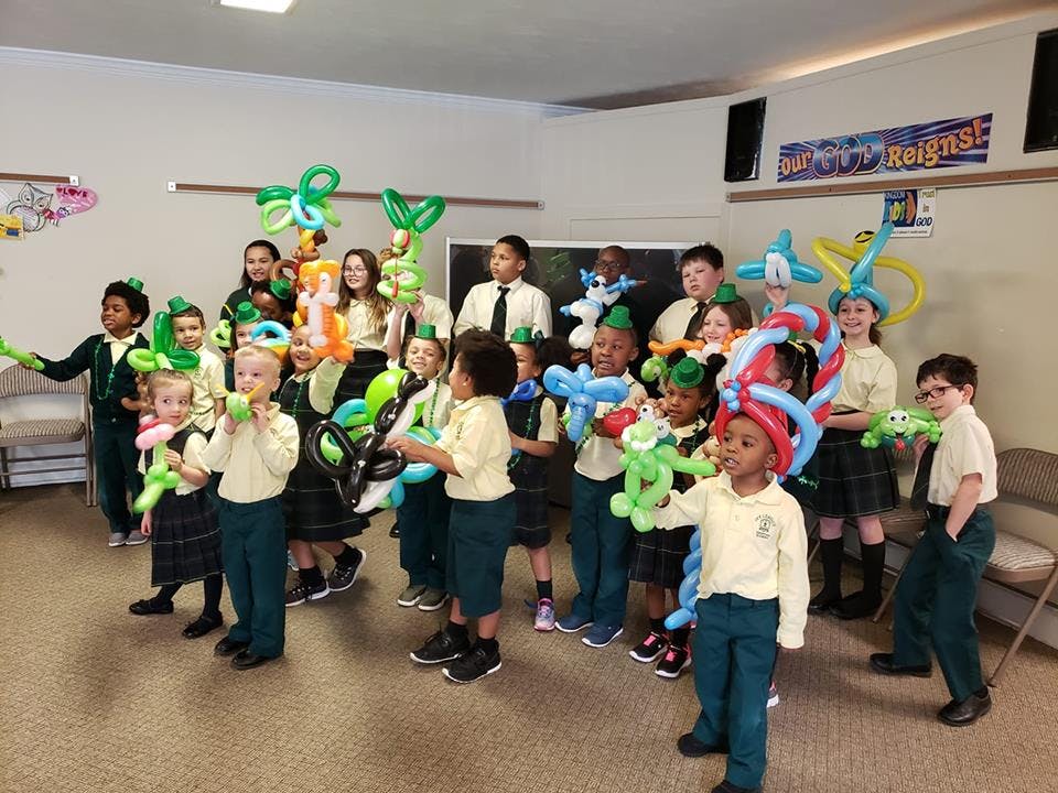 Group of children and teens holding balloon animals