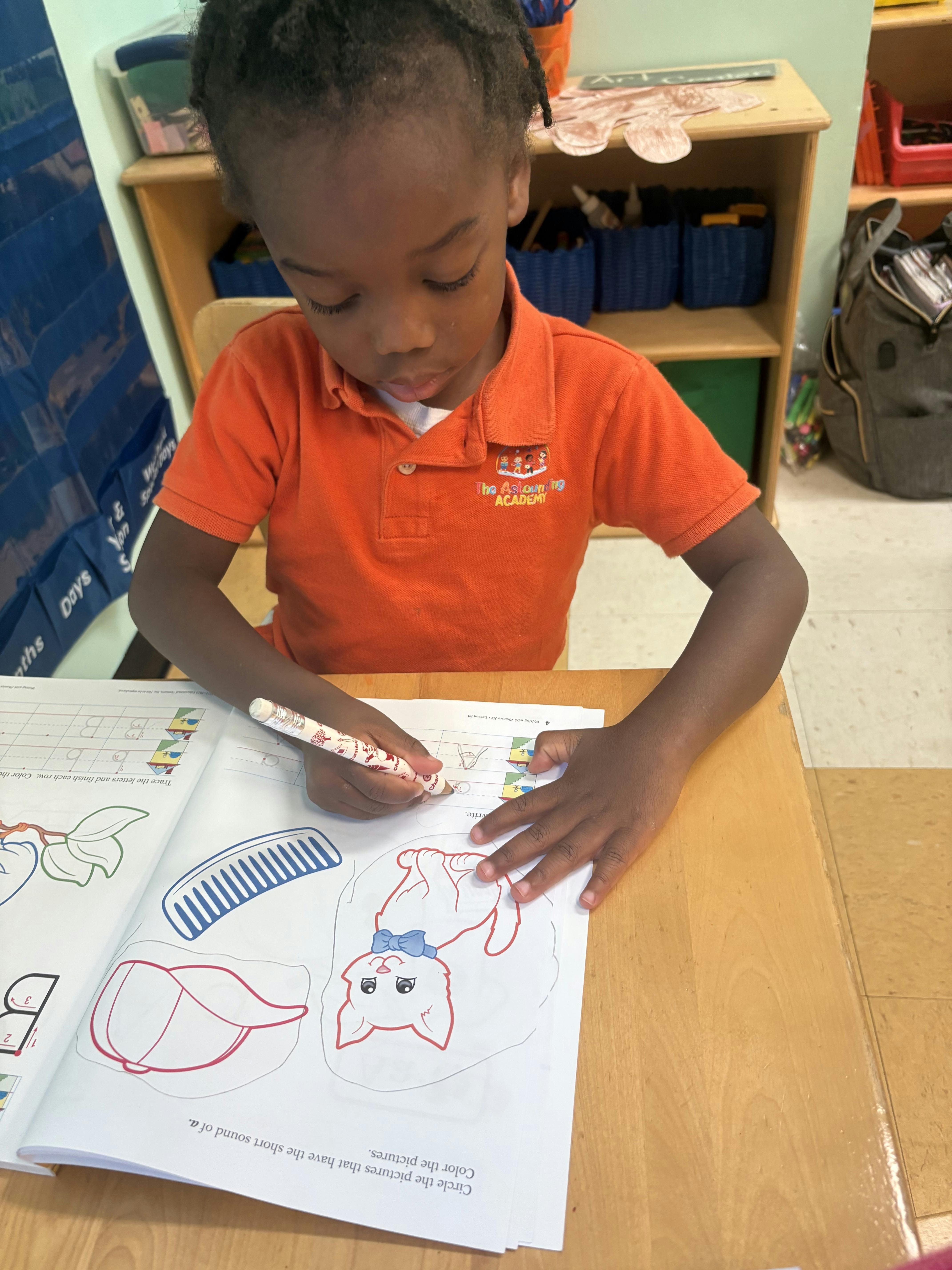 Child coloring in a book at a desk